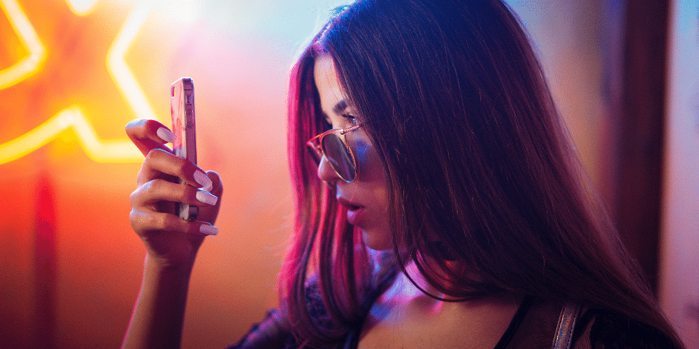 Neon woman looking at social media on phone